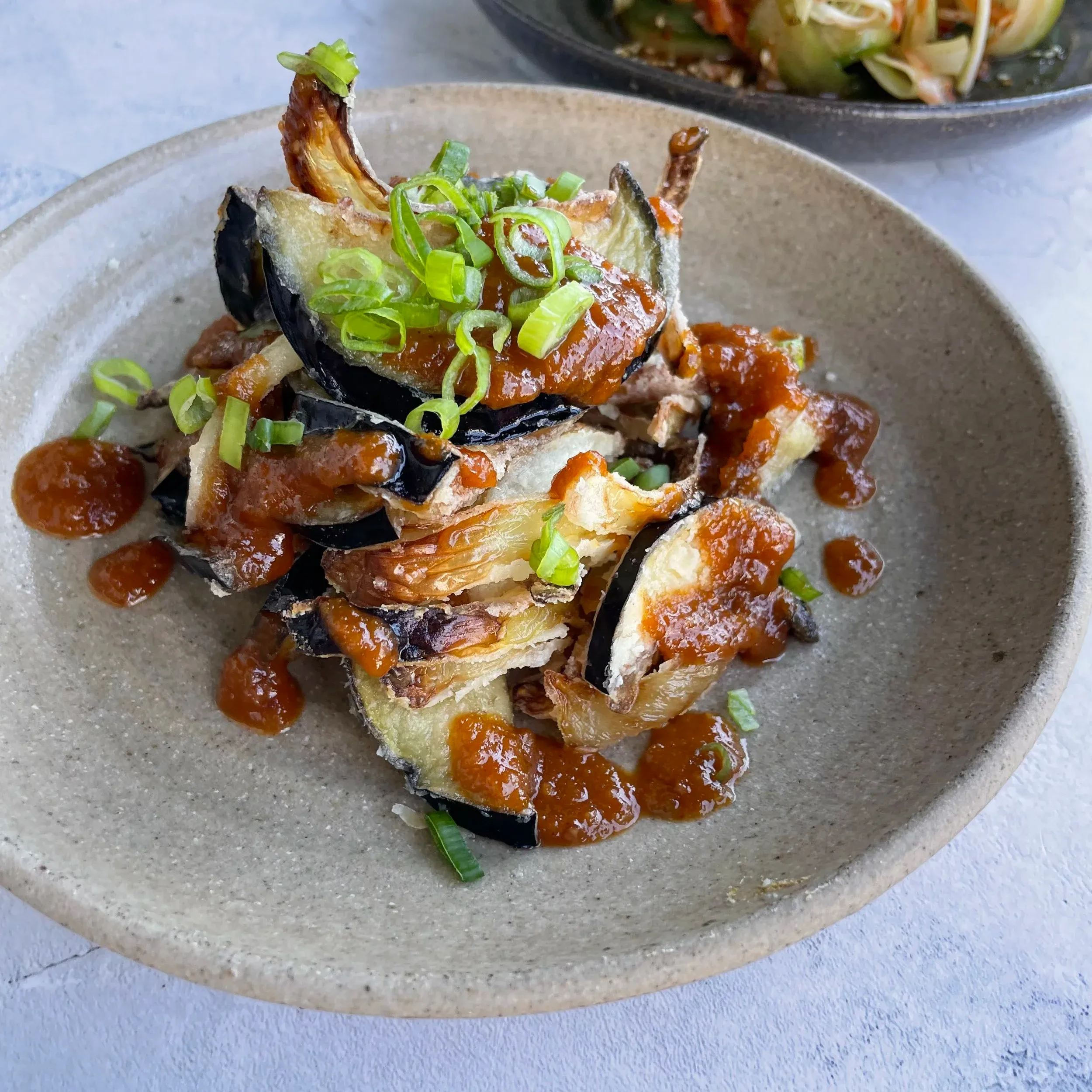 Fried aubergines with gochujang sauce and spring onions